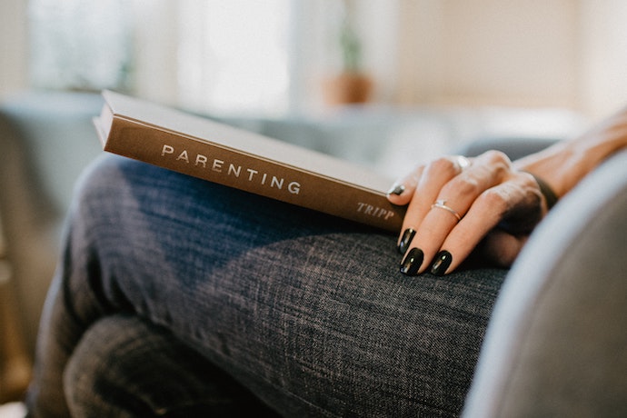 a womans hand rests on a parenting book