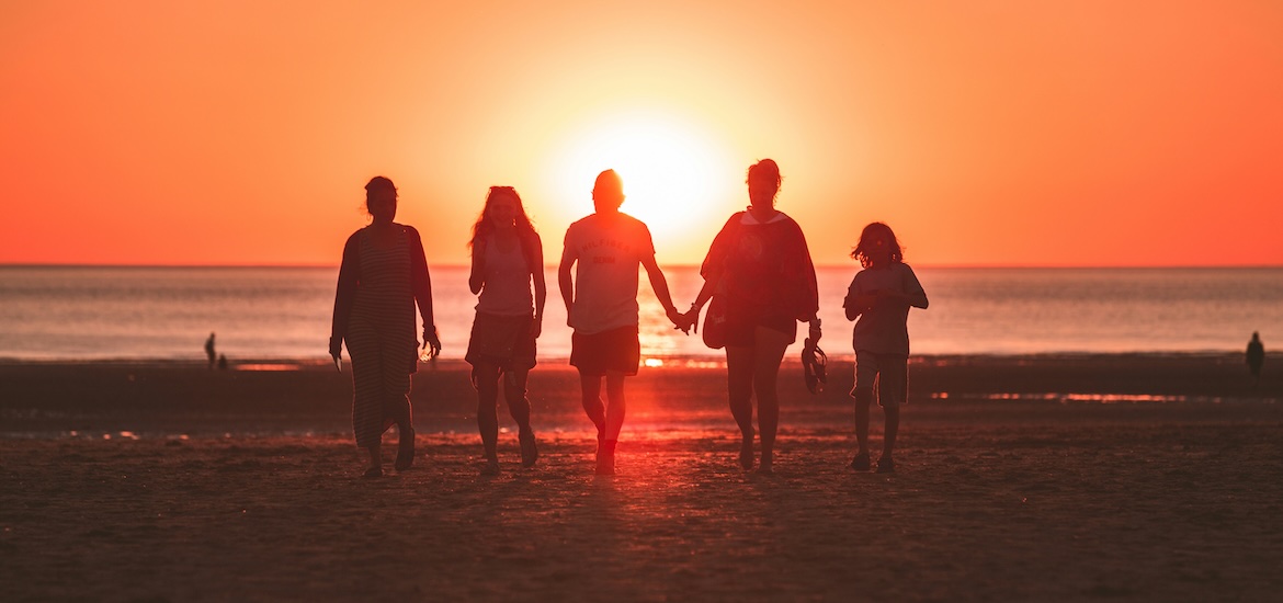 Family on beach at sunset