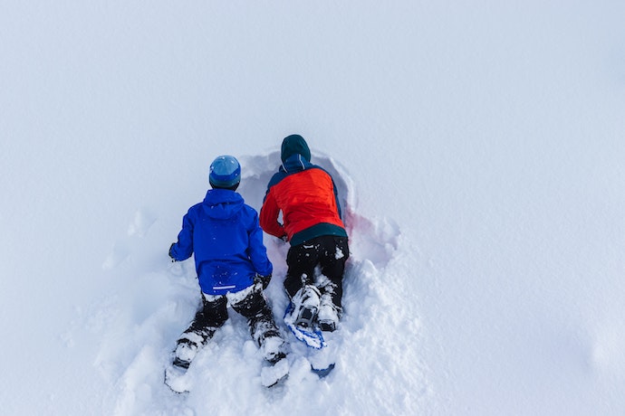 2 children sliding in the snow