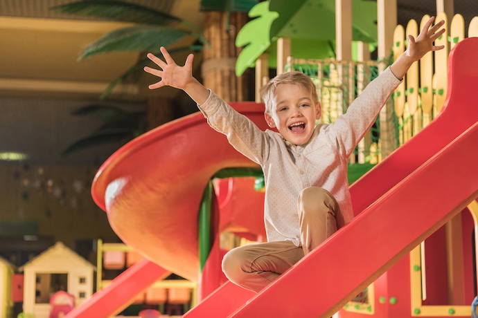 kid in play center on slide