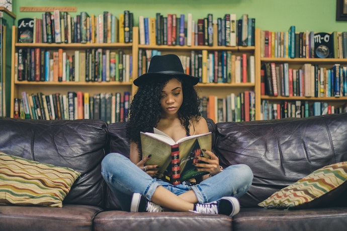 a teenage girl reads in a library