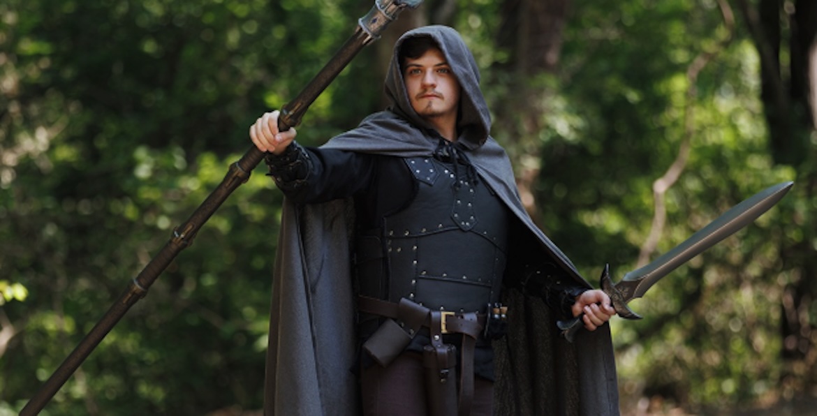 Cloaked fantasy warrior with staff and sword