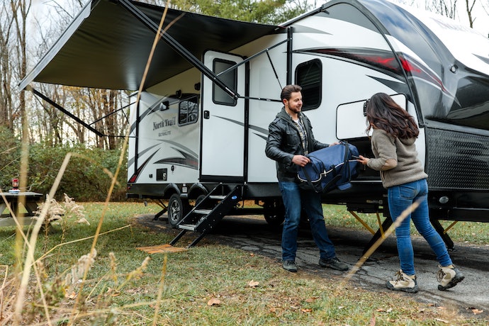 A couple outside a large RV