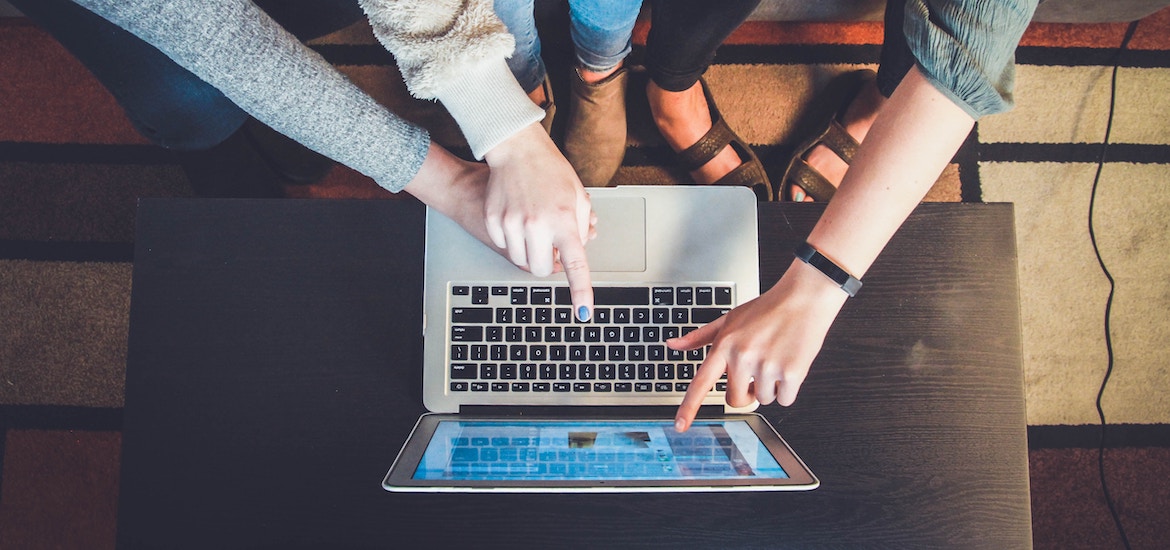 hands of family pointing at computer laptop online safety for kids family days out