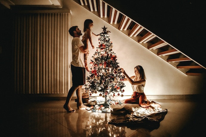 girl adds fairy to xmas tree