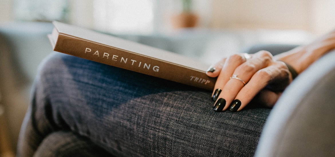 a female hand holds a parenting book