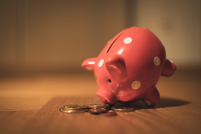 a pink piggy bank and coins