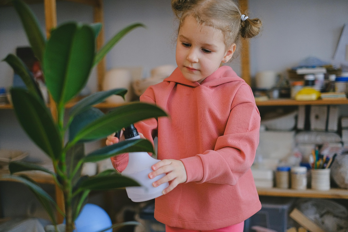 little girl waters plant