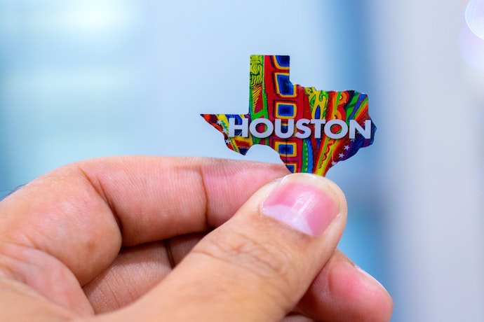 a hand holding a small sign saying Houston