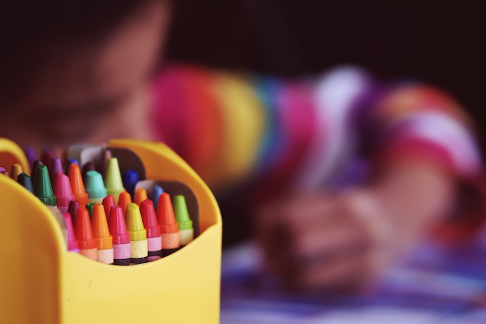 a boy colors and close up of colorful crayons