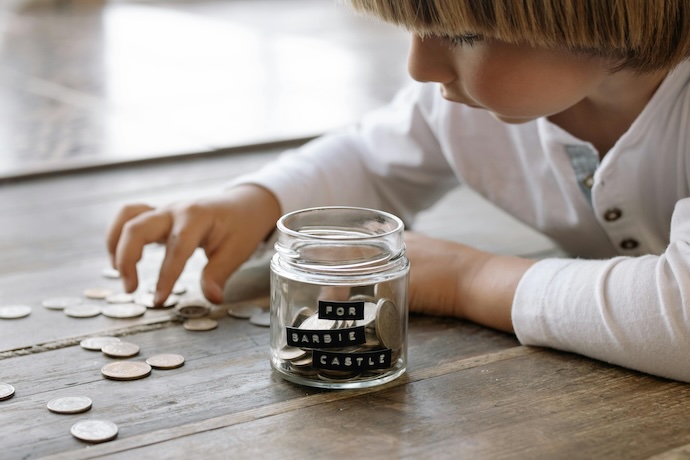 kid filling jar with savings
