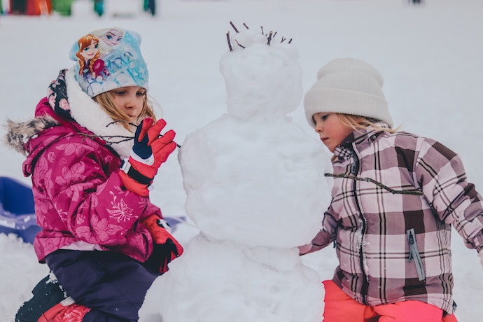 2 children build a snowman