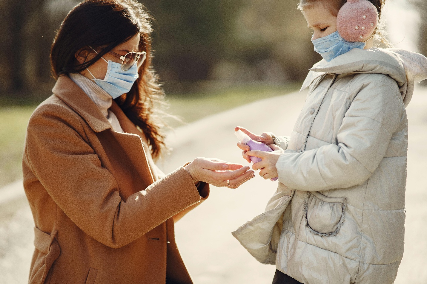 mum giving hand sanitiser to daughter