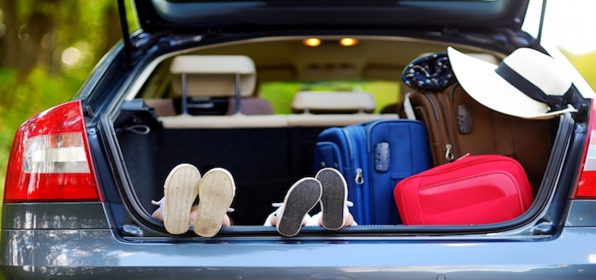 kids feet in car ready for road trip packed luggage