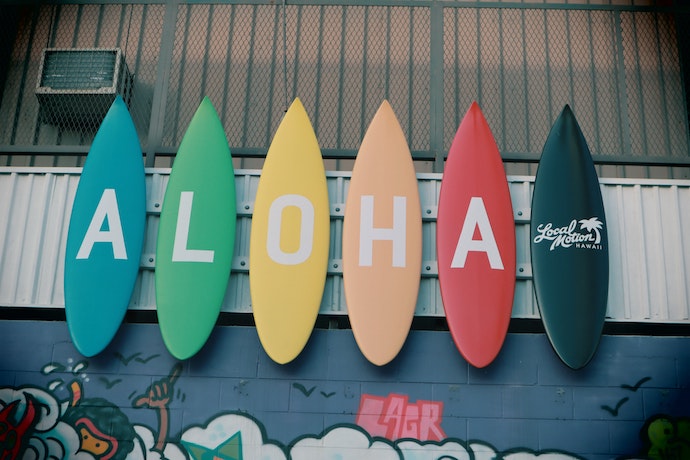 A series of colorful surfboards that spell Aloha