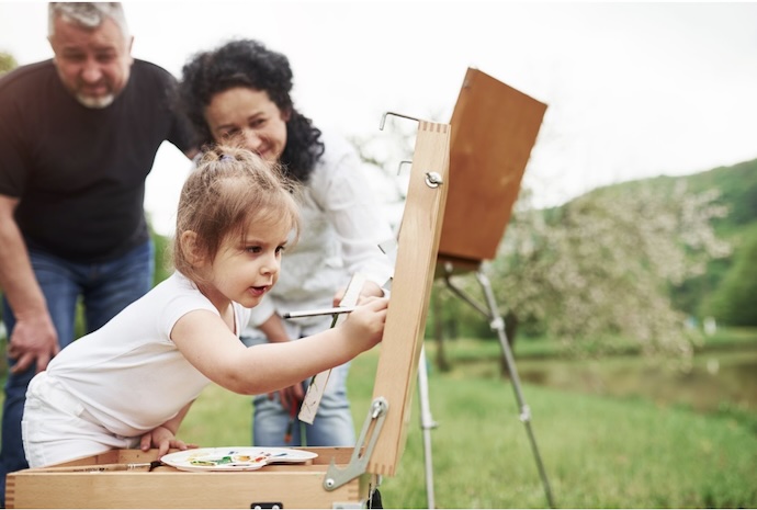 girl paints as parents watch