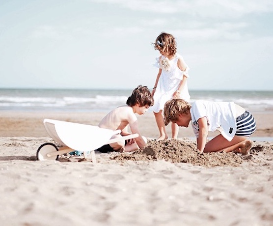 three children play on a lovely beach