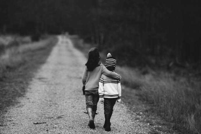 A sister with her arm around her brother