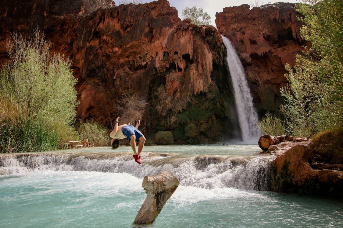 a boy does a backflip into the river
