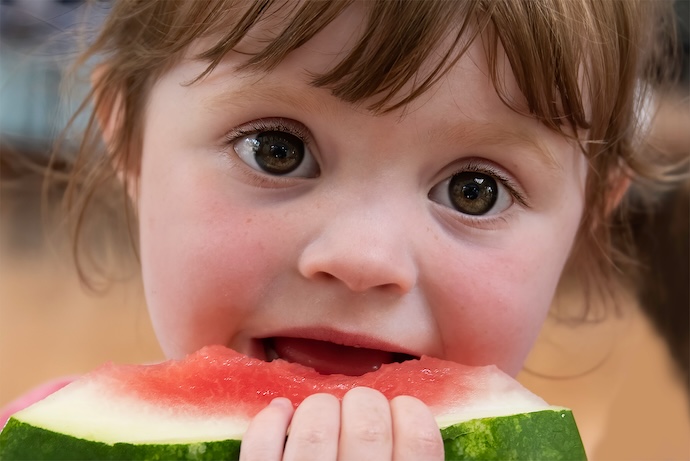 a toddler eats some watermelon