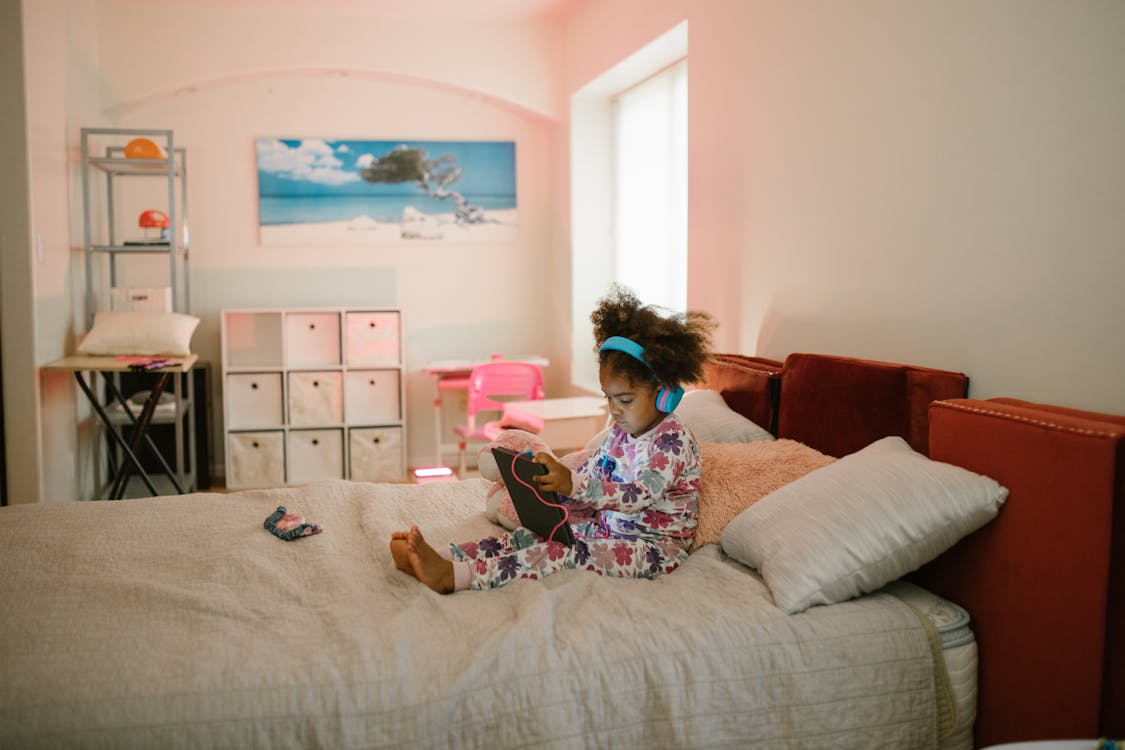 a young girl on an ipad in bed