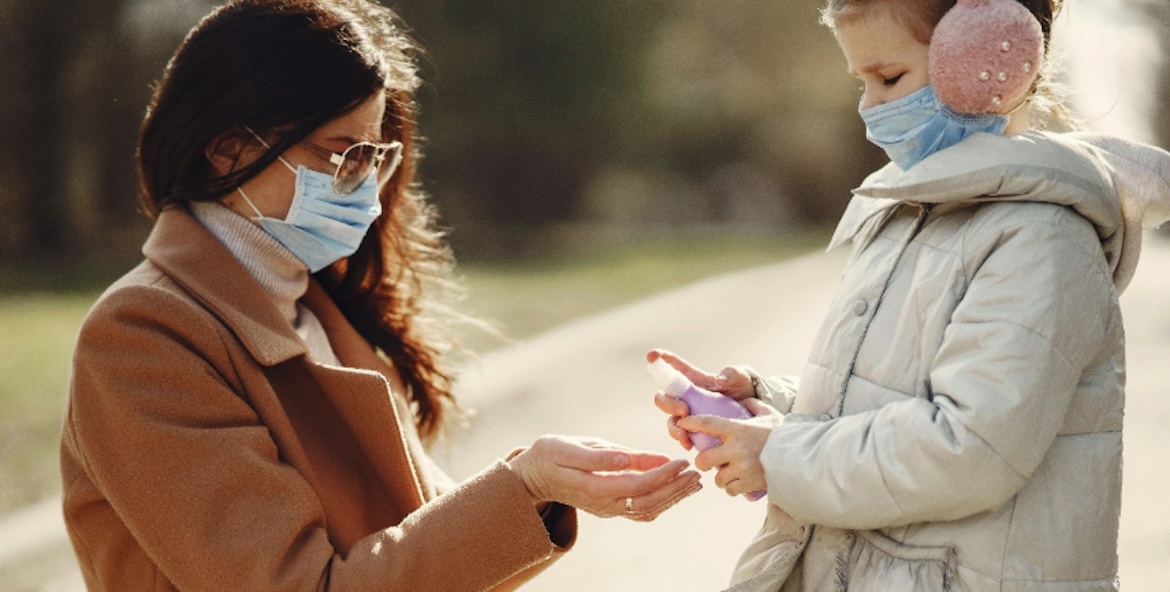 Mum giving daughter hand sanitsier