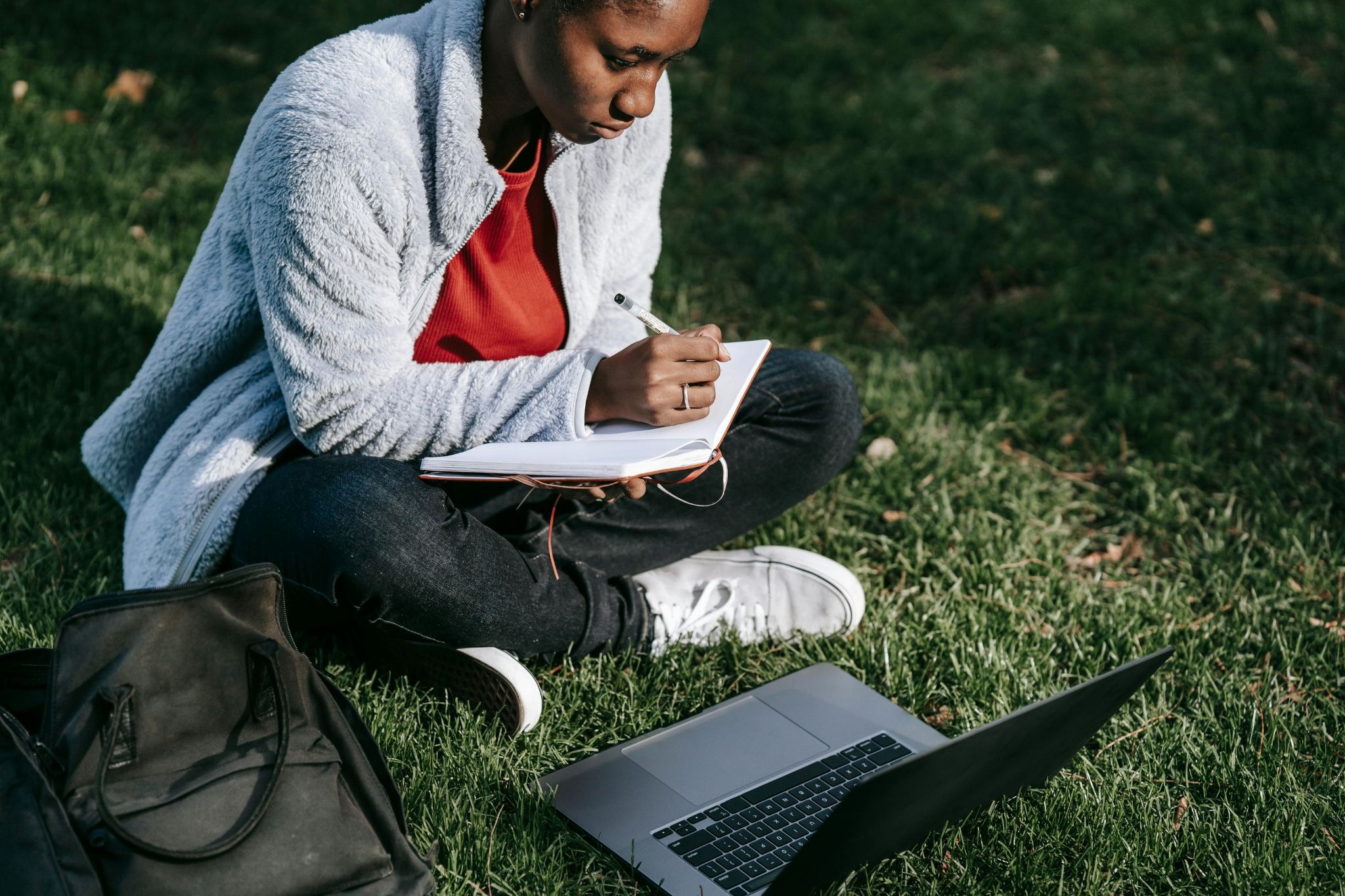 female student making notes outside
