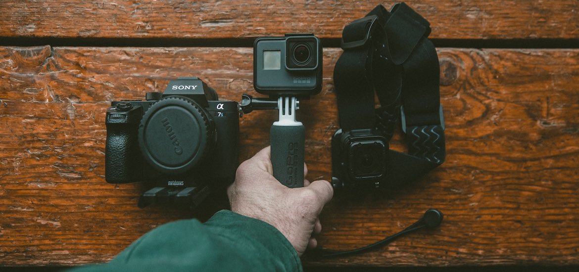 a hand holding a go-pro camera and equipment