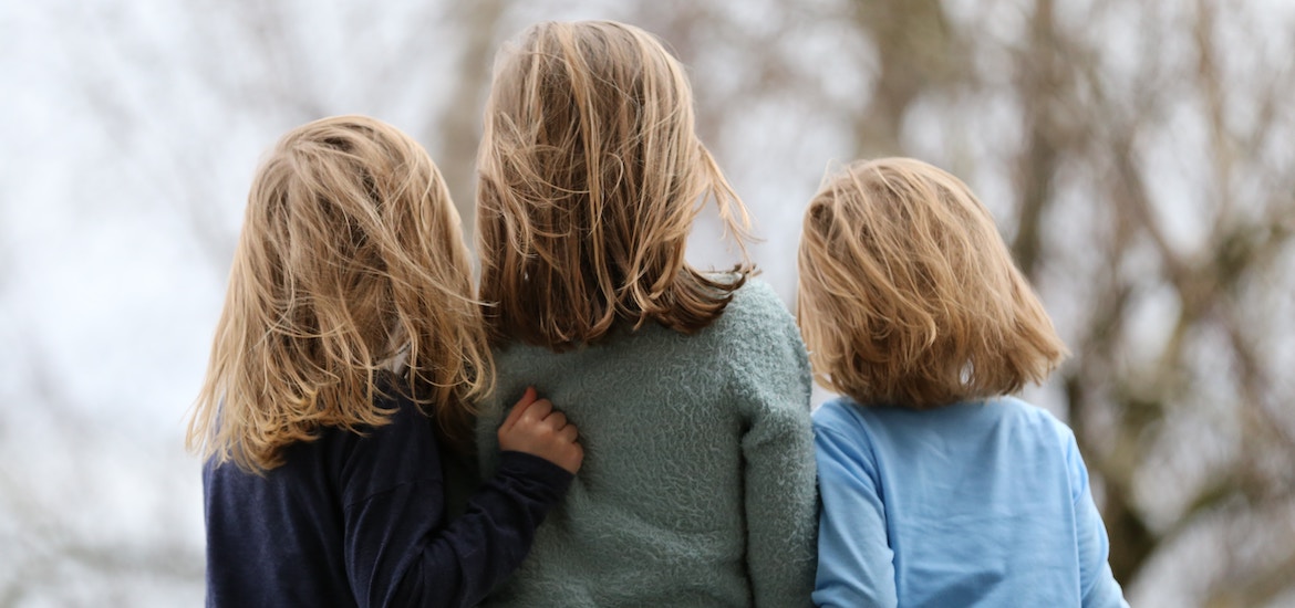 siblings children back of heads hugging