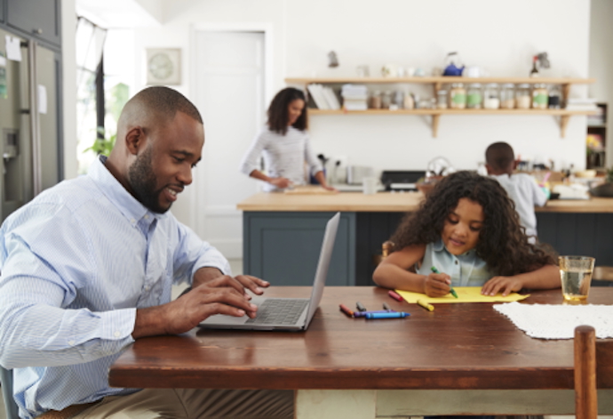 dad on laptop and daughter playing