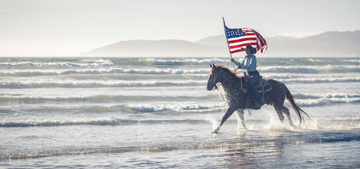 Man riding a horse with American flag