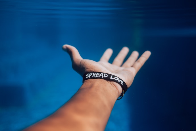 a hand with a spread love bracelet on