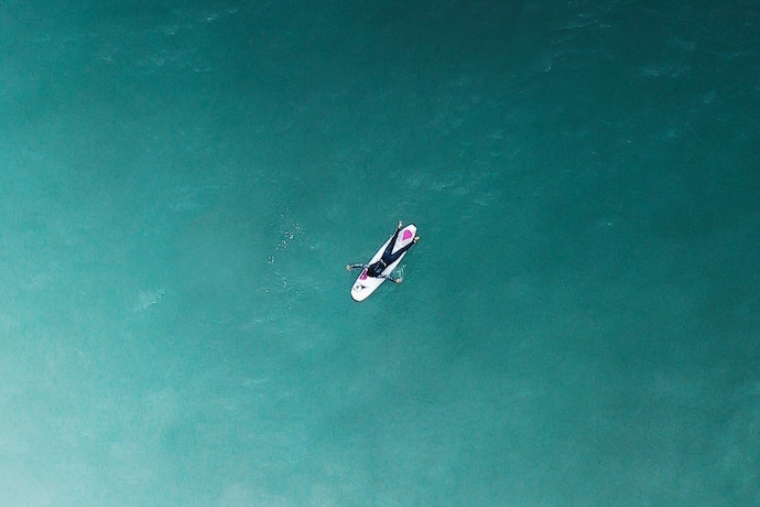 a surfer paddles out to see