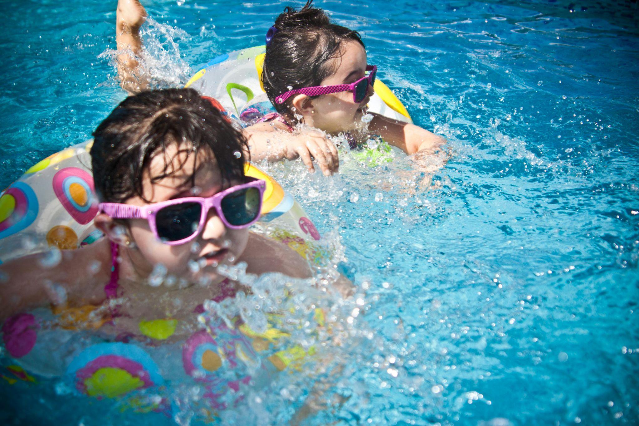 two kids play ion the pool