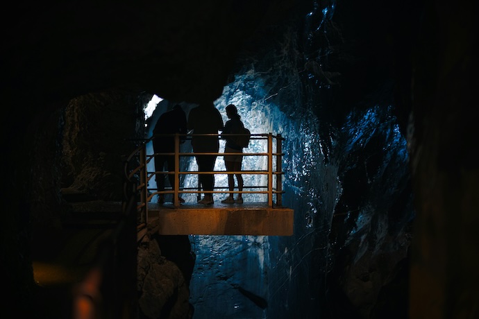 People standing on a platform in a cave