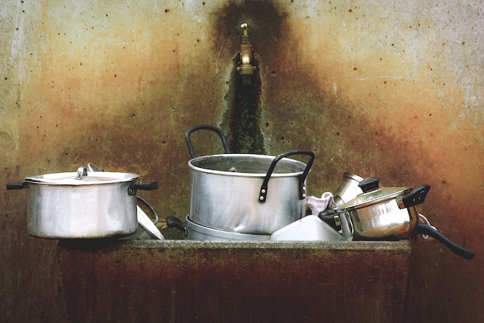 unwashed pots and pans in a sink