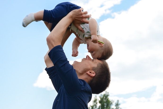 a dad bounces his baby boy in his arms