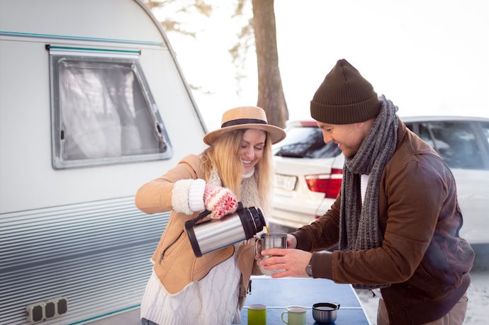 couple making coffee outside RV