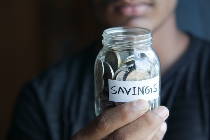 a man holds a jar of savings