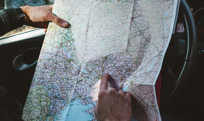 hands reading map in car