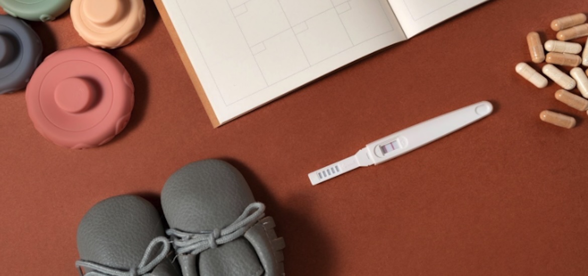 Pregnancy tester and baby items on a table