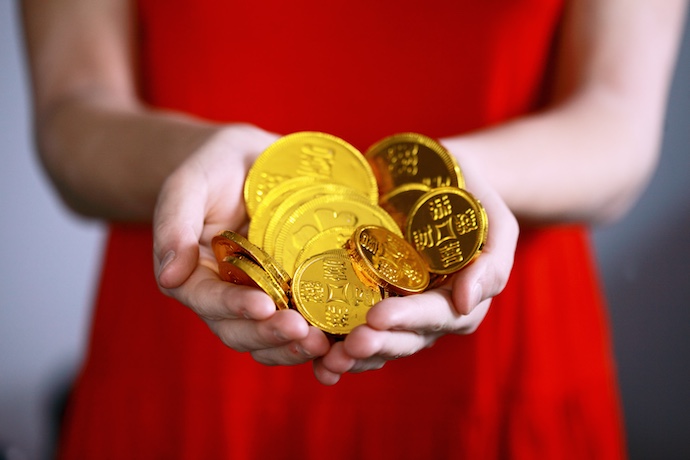 a hand holding gold coins