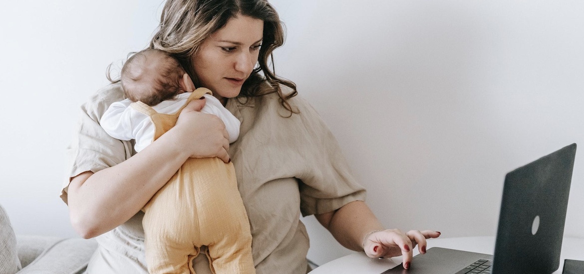mother working at computer laptop with baby working from home