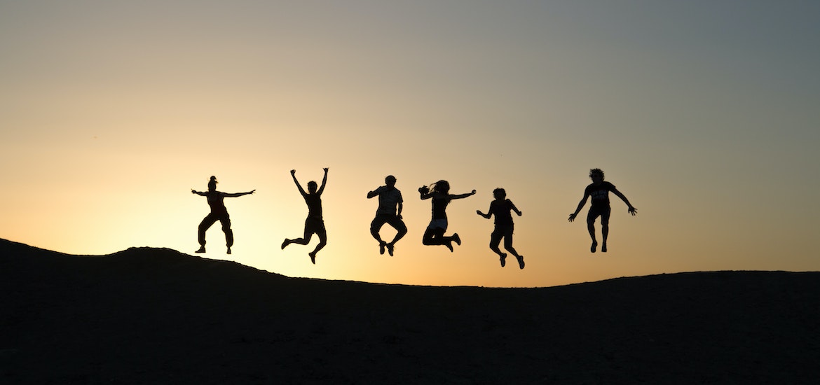 people jumping in the air at sunset silhouette family days out slip slop slap seek slide