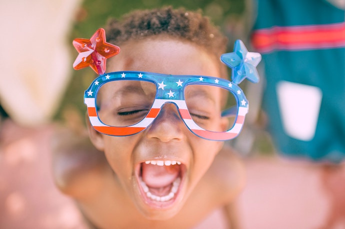 boy with red , white and blue american sunglasses on smiling.