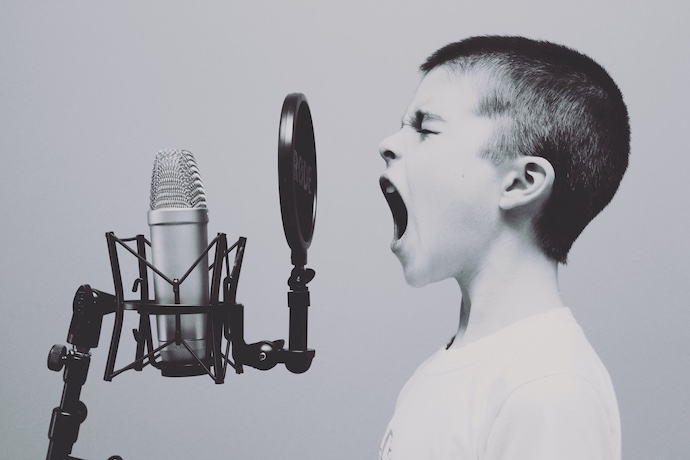 a boy shouts into a microphone