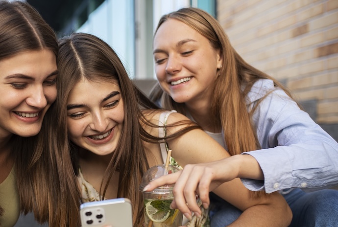 three girls looking at iphone