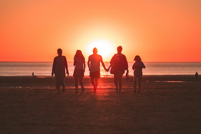 family on beach at sunset