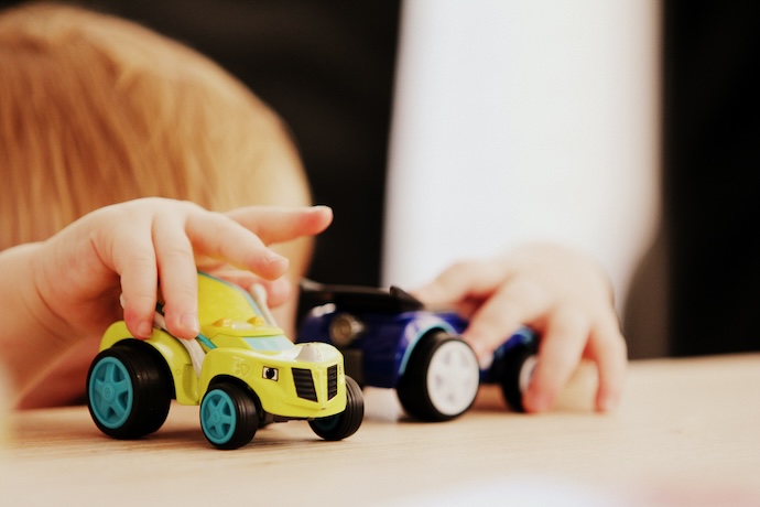 a toddler plays with toy cars