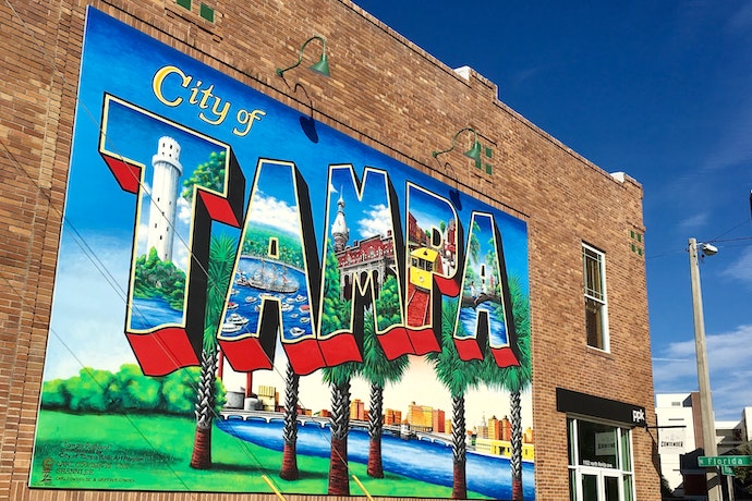 A sign saying city of Tampa on a brick wall